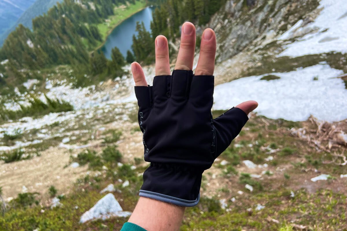 Durable technical hiking gloves resting on a mountain rock during a hiking trip.