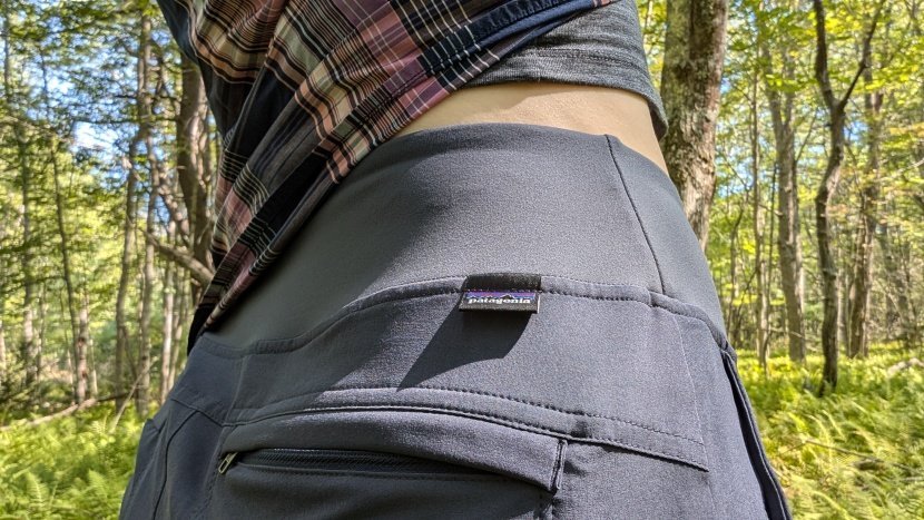 A female hiker wearing versatile convertible hiking pants while standing on a mountain trail.
