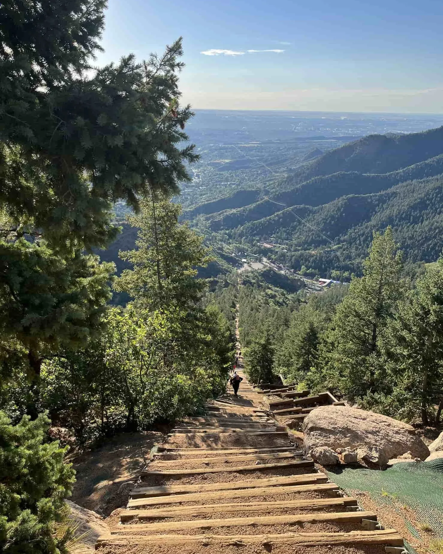 Hiker with trekking poles pausing at a forked Colorado trail