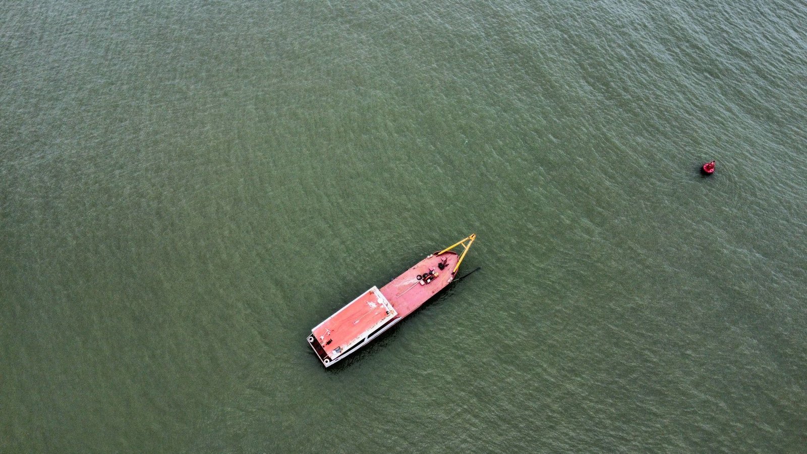 A professional fishing drone hovers over a tranquil lake at golden hour.