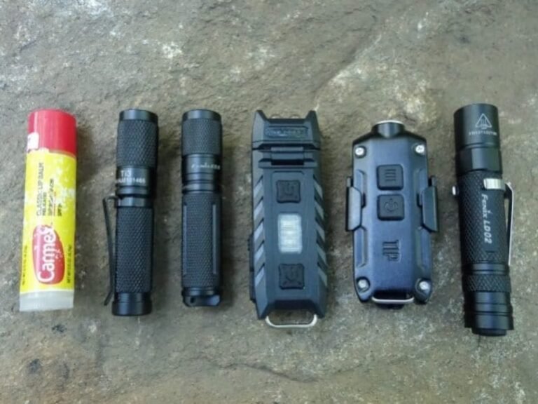 A professional LED hiking torch rests on a rock in a forest.