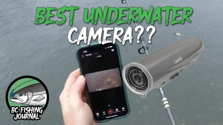 A professional underwater fishing camera held above a clear lake at sunrise.