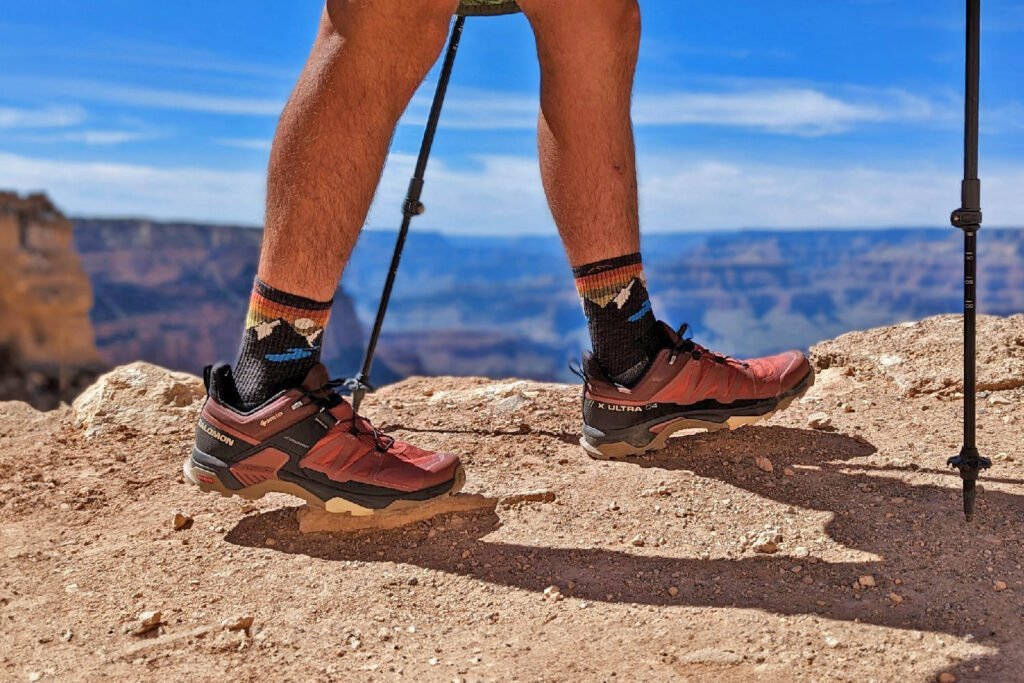 Thick wool hiking socks resting inside a leather hiking boot outdoors.