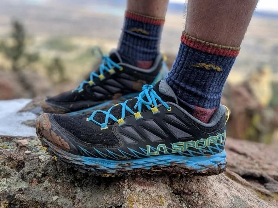 A thin sock liner layered under a thick wool hiking sock outdoors.