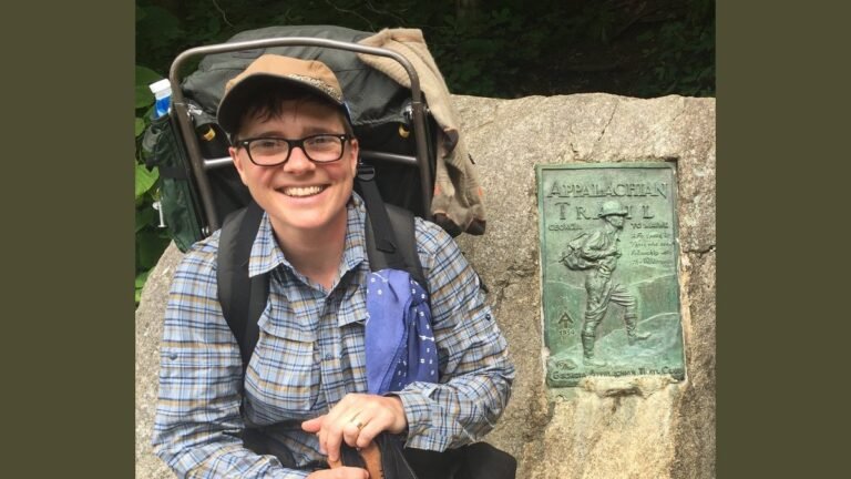 Wraparound prescription hiking glasses resting on a granite rock in a pine forest.